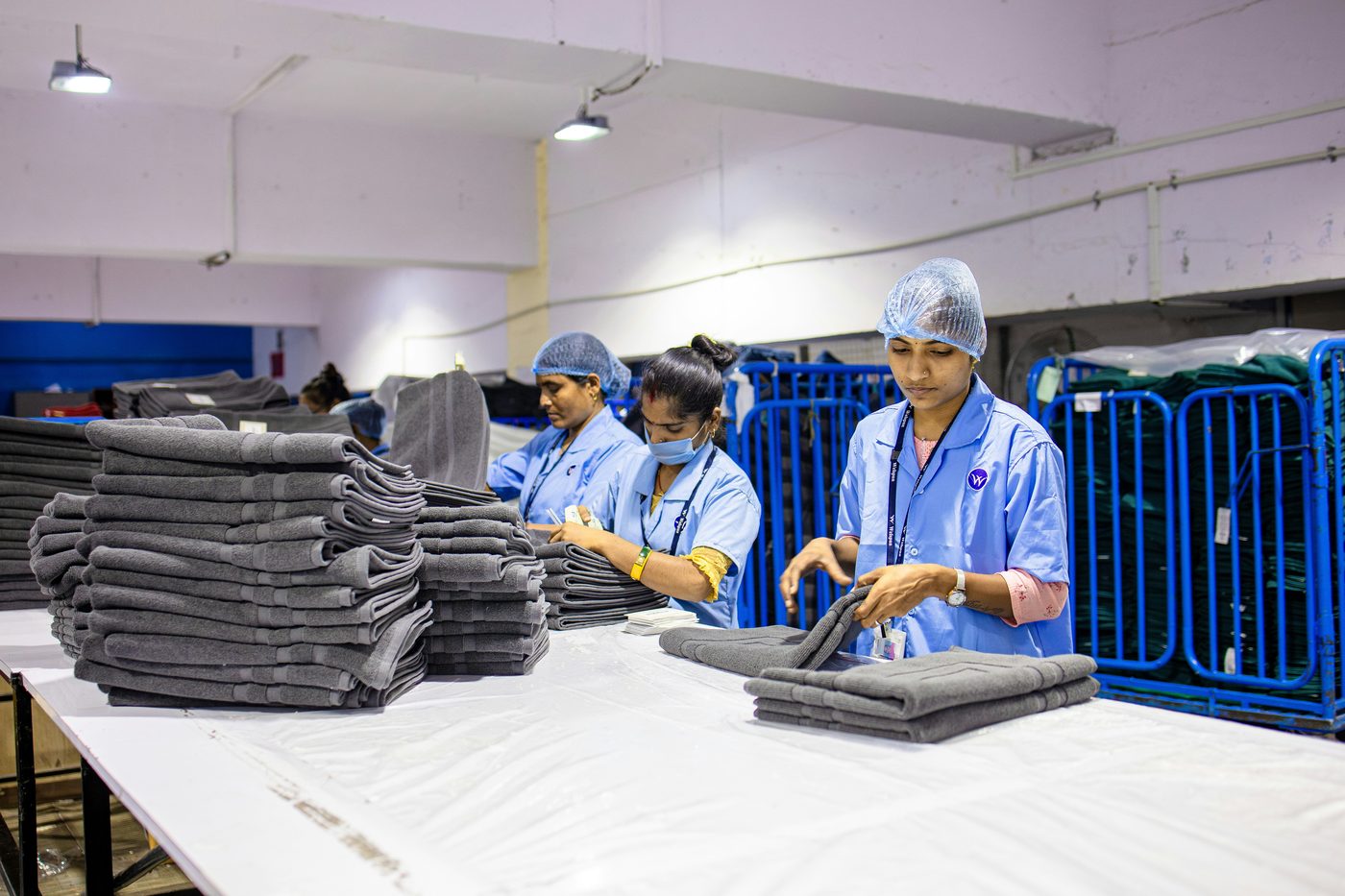 Drop Off laundry service - folded towels and staff at work